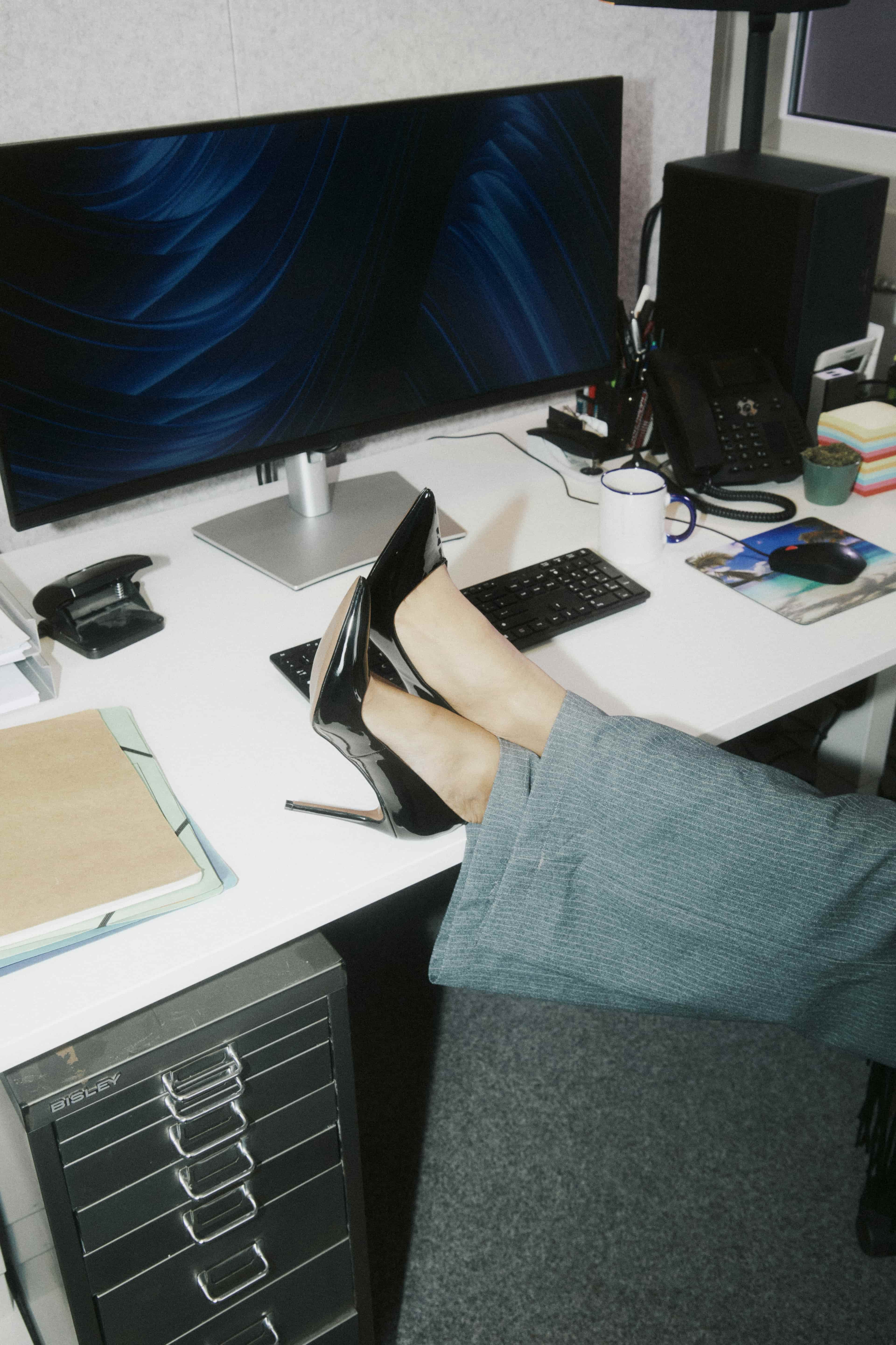 Een persoon met de voeten op een bureau