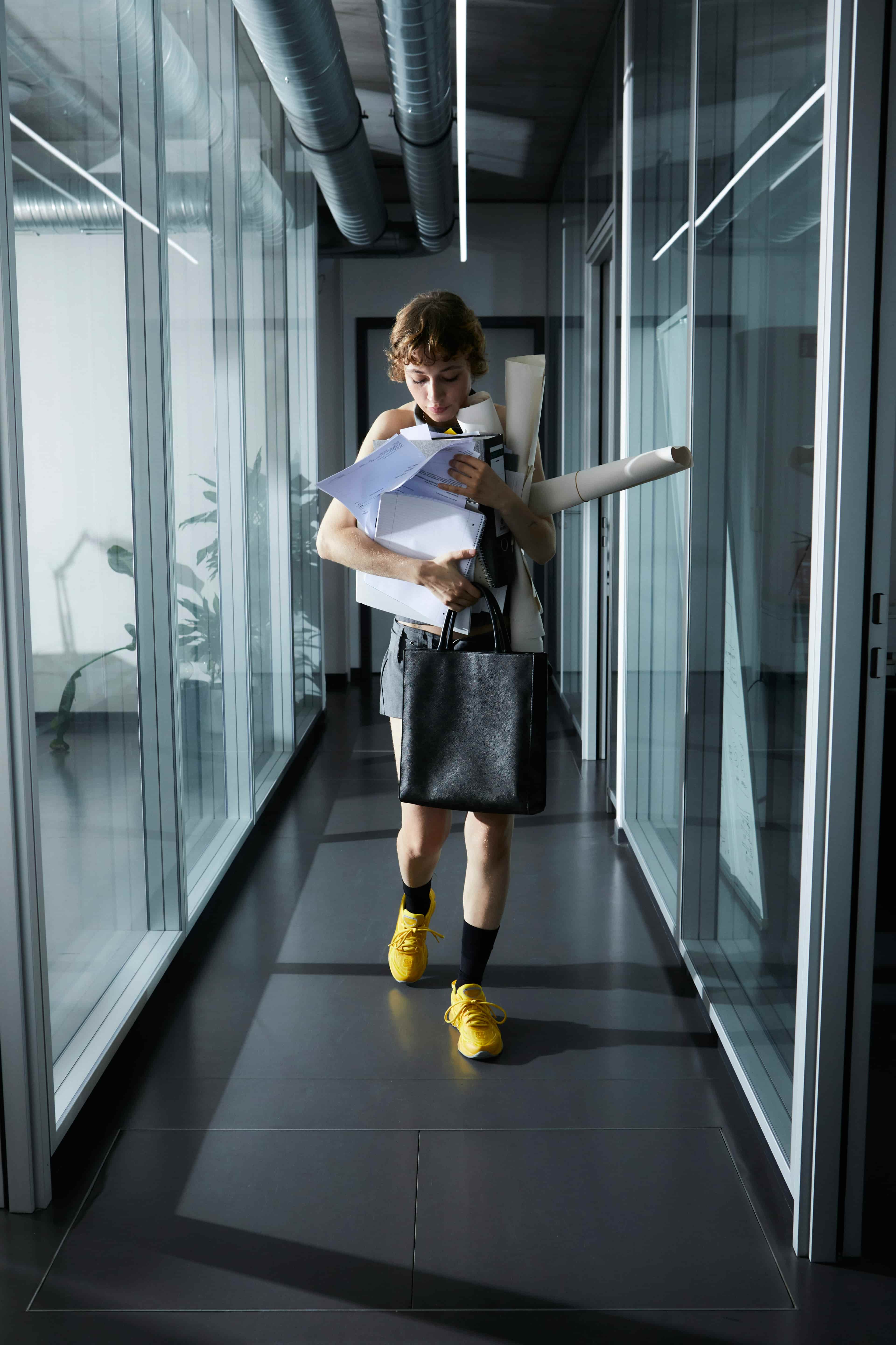 A woman walking through a hallway in an office environment